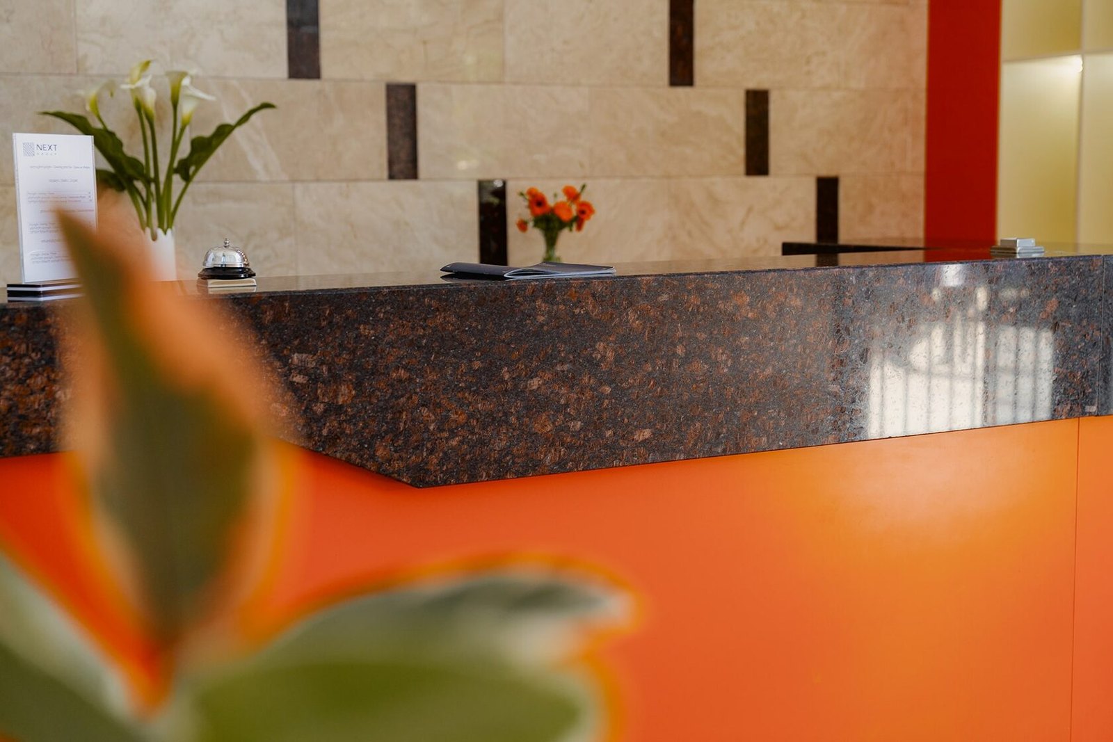 Reception desk and orange seating at NEXT Orange