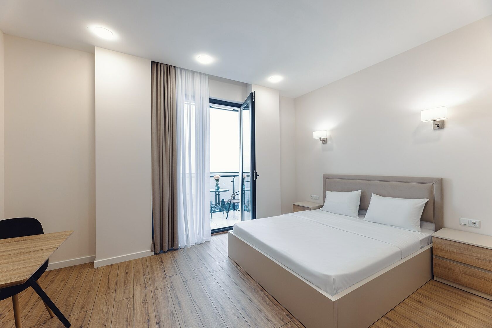 A furnished NEXT Green bedroom with a balcony